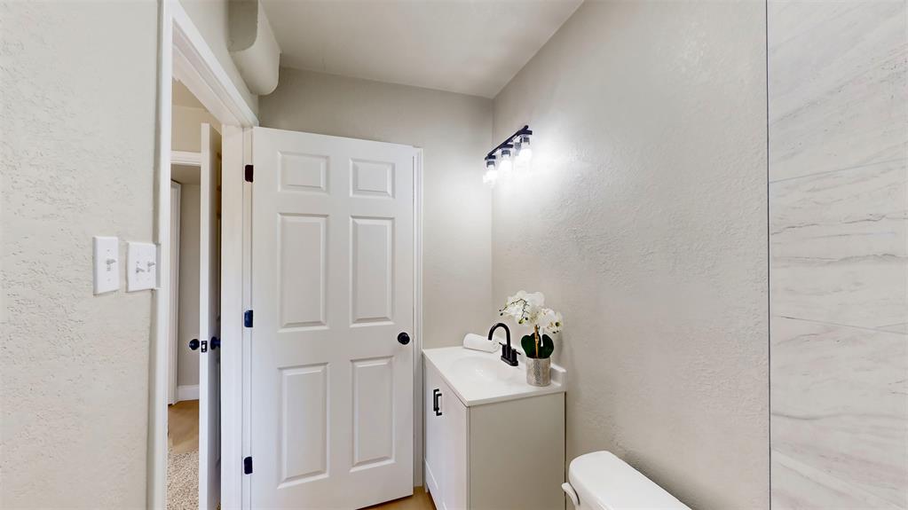5009 Roxie Street Haltom City, TX 76117 - Photo 30 of 39 a bathroom with a toilet and a sink