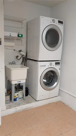 a utility room with sink dryer and washer