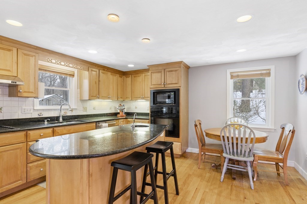 7 Longfellow Road Lexington, MA 02420 - Photo 6 of 30 a kitchen with stainless steel appliances granite countertop a stove a sink a table and chairs
