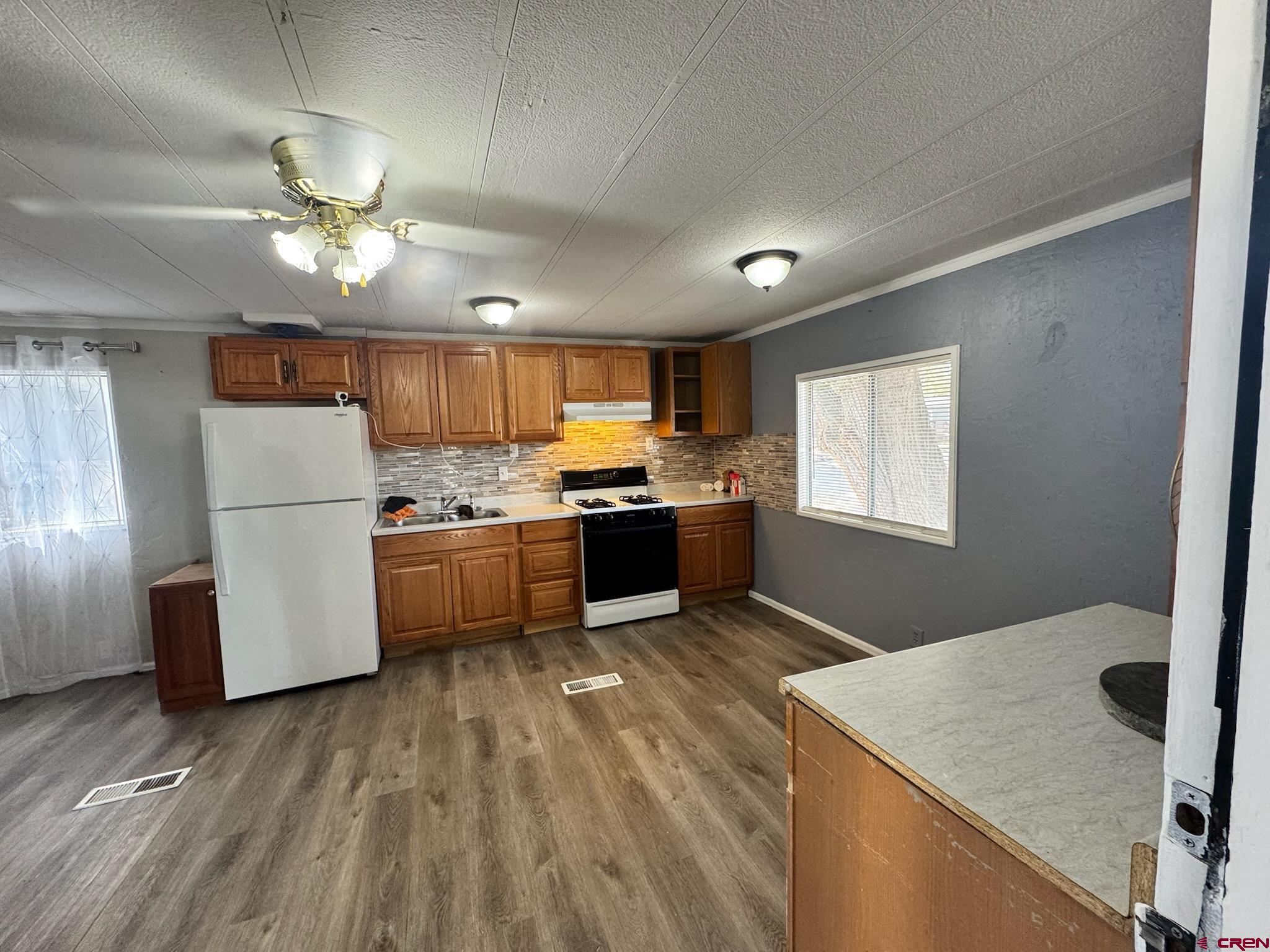 14555 Marine Road, Unit 328 Montrose, CO 81403 - Photo 3 of 20 a kitchen with kitchen island white cabinets and stainless steel appliances