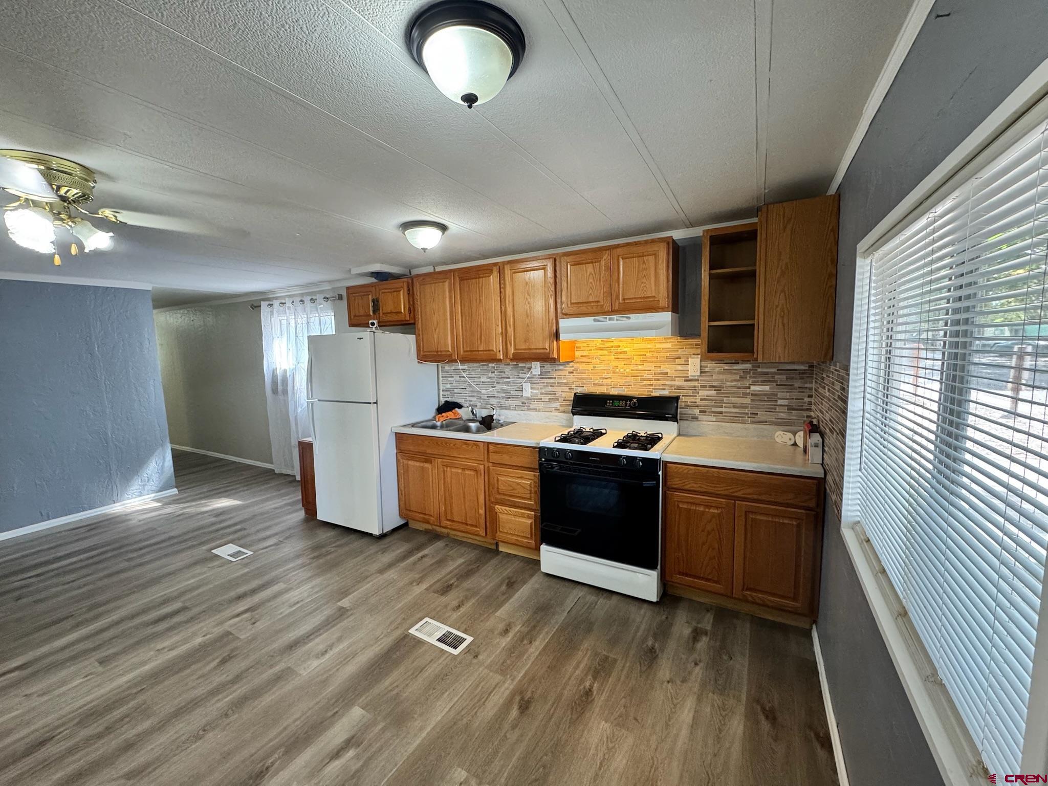 14555 Marine Road, Unit 328 Montrose, CO 81403 - Photo 4 of 20 a kitchen with granite countertop a refrigerator stove top oven and sink