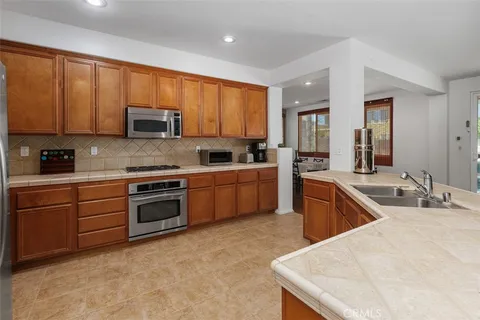 a kitchen with stainless steel appliances granite countertop a sink stove microwave and refrigerator