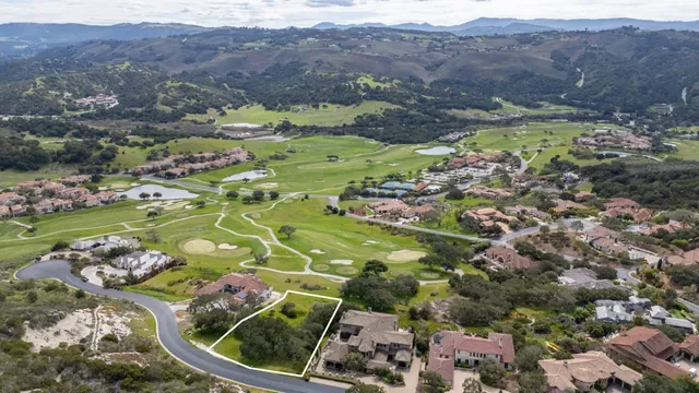 an aerial view of a golf course with a lake