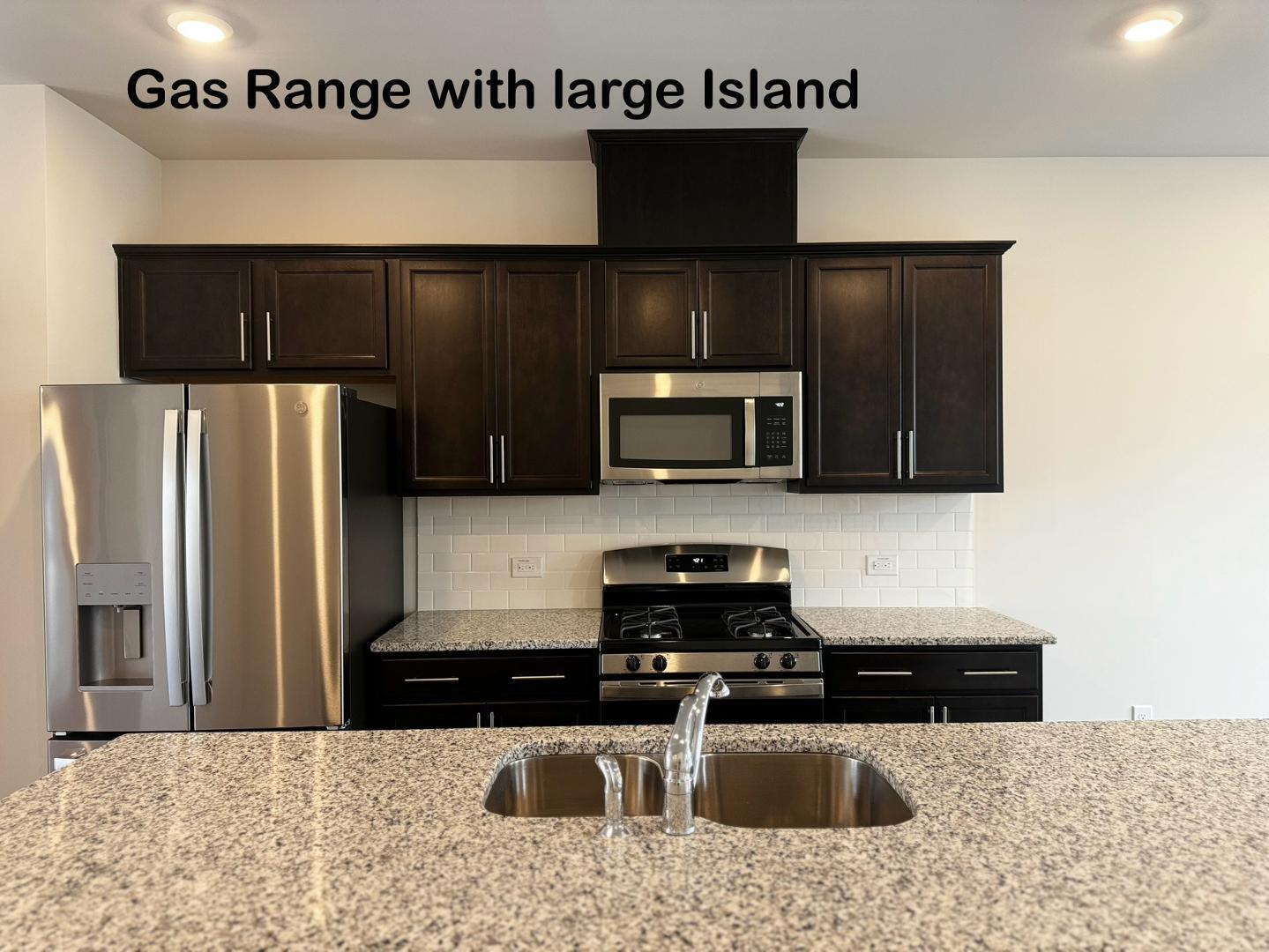 152 Sweet Lilac Way Raleigh, NC 27610 - Photo 12 of 40 a kitchen with stainless steel appliances granite countertop a sink a stove a microwave and a refrigerator