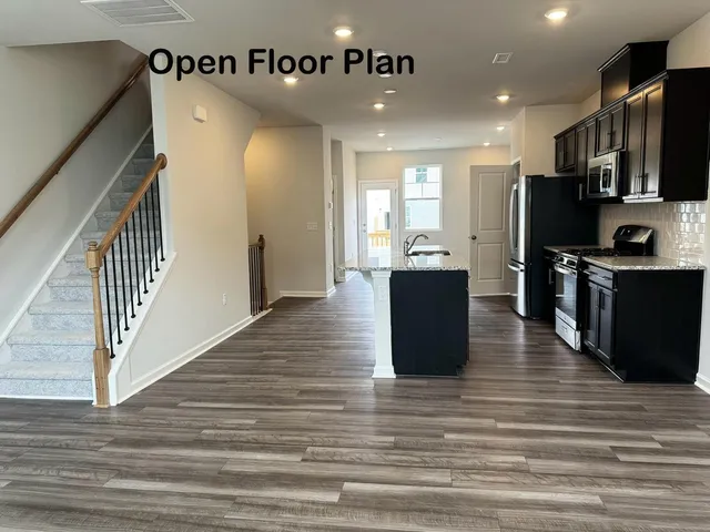 a view of a kitchen with cabinets stainless steel appliances and wooden floor