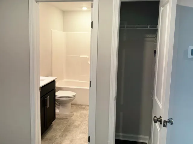 a bathroom with a granite countertop toilet and a shower