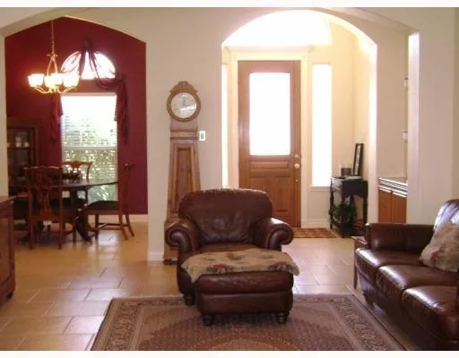 a living room with furniture and a large mirror next to a window
