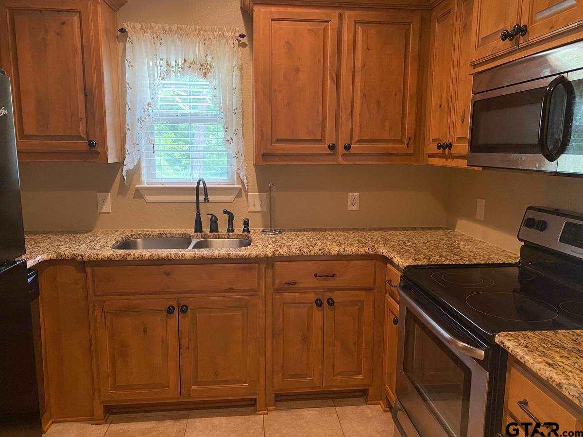 200 Water Street, Unit B Bullard, TX 75757 - Photo 6 of 14 a kitchen with a sink stove and microwave