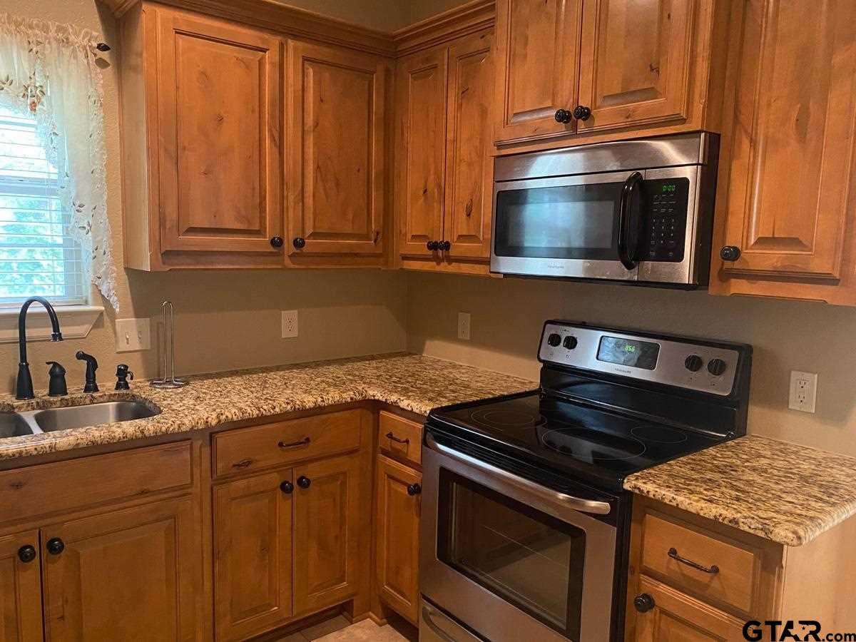 200 Water Street, Unit B Bullard, TX 75757 - Photo 7 of 14 a kitchen with granite countertop a stove and a sink