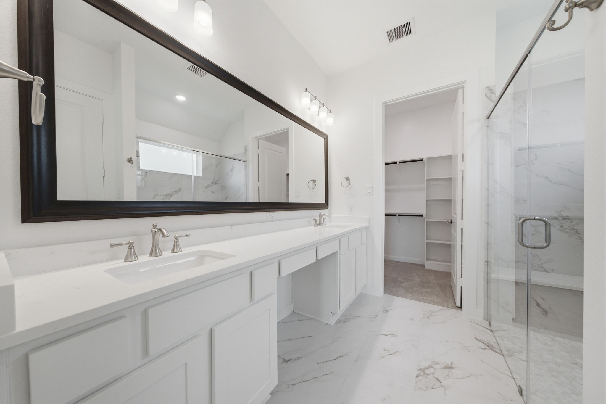 21952 Rolling Grns Road Porter, TX 77365 - Photo 25 of 43 Beautiful primary bath with dual vanities, an oversized mirror, walk-in shower, and direct access to a generous walk-in closet.