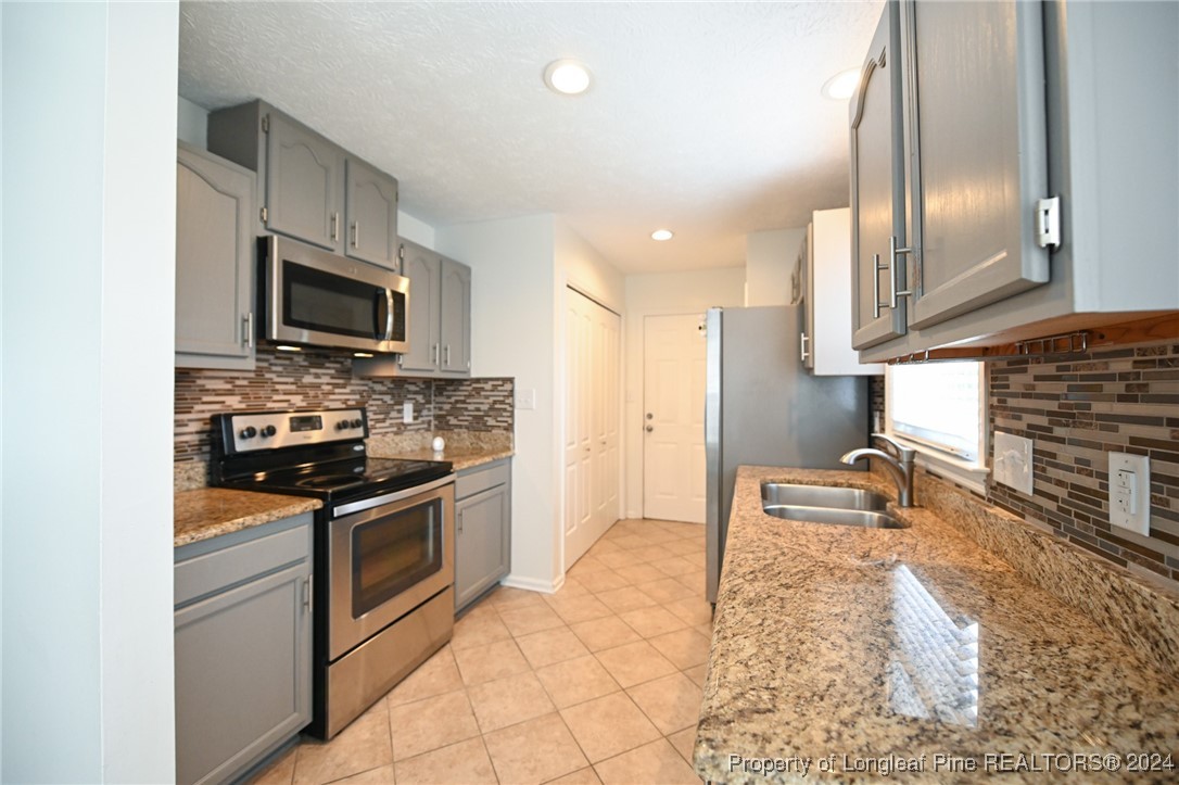 5057 Summer Ridge Road Fayetteville, NC 28303 - Photo 12 of 29 a kitchen with stainless steel appliances granite countertop a stove a sink and a microwave