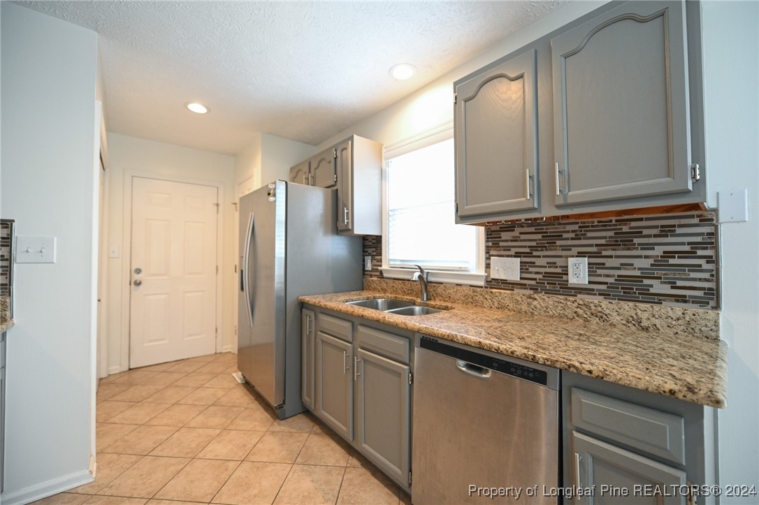 5057 Summer Ridge Road Fayetteville, NC 28303 - Photo 13 of 29 a kitchen with stainless steel appliances granite countertop a sink stove and refrigerator