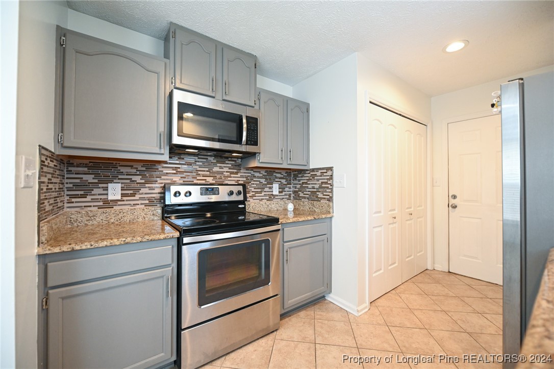5057 Summer Ridge Road Fayetteville, NC 28303 - Photo 14 of 29 a kitchen with stainless steel appliances granite countertop a stove a microwave and a refrigerator