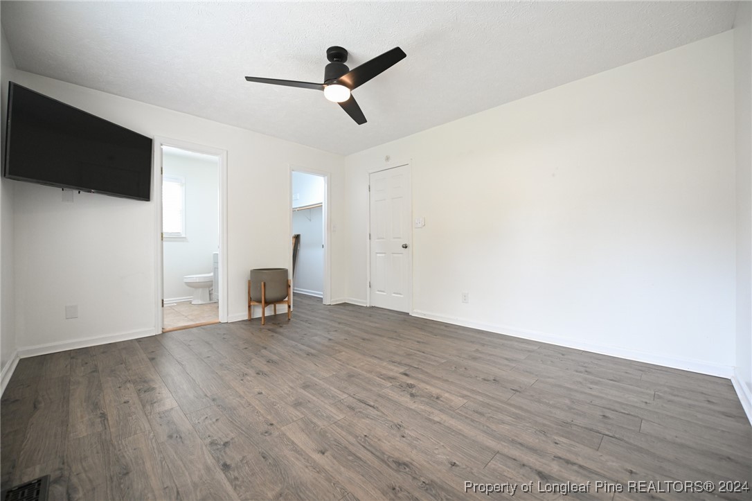 5057 Summer Ridge Road Fayetteville, NC 28303 - Photo 19 of 29 a view of an empty room with wooden floor and a ceiling fan