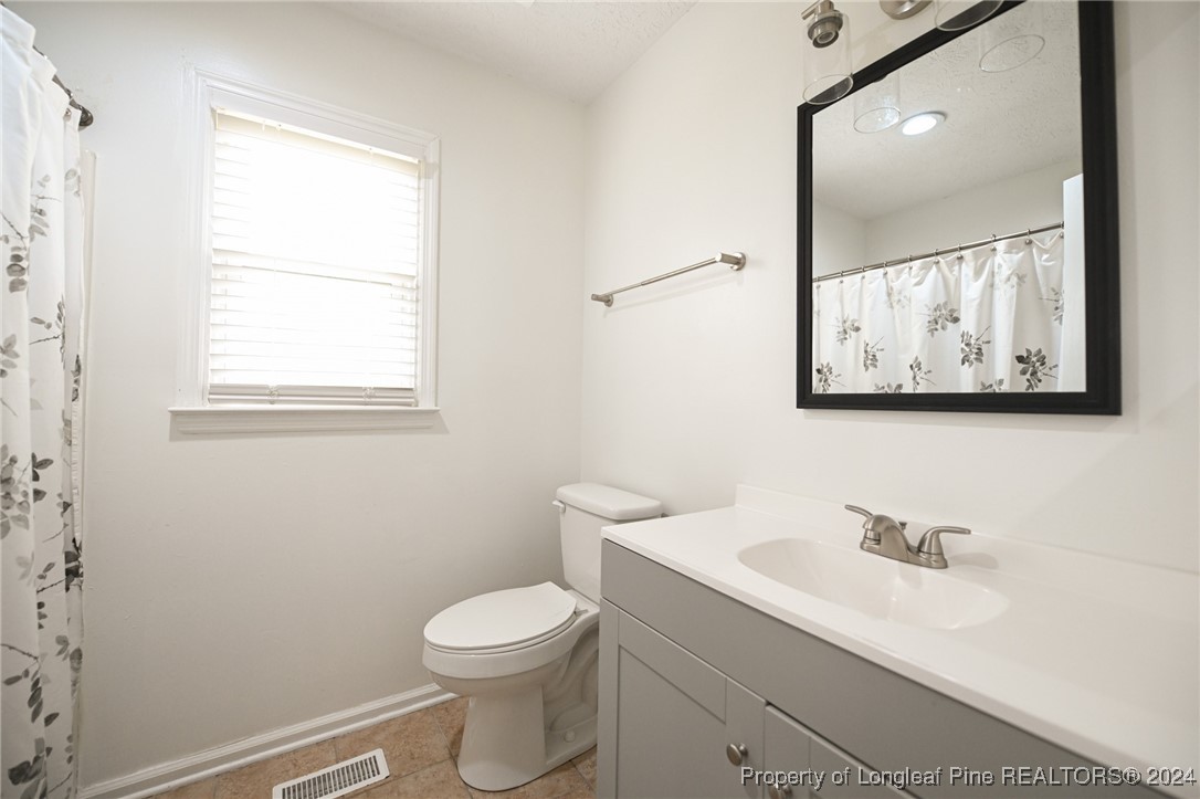 5057 Summer Ridge Road Fayetteville, NC 28303 - Photo 20 of 29 a bathroom with a toilet a sink and mirror