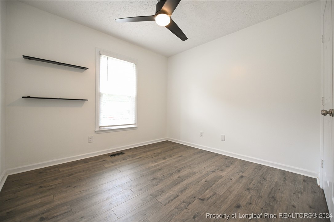 5057 Summer Ridge Road Fayetteville, NC 28303 - Photo 21 of 29 an empty room with wooden floor ceiling fan and windows