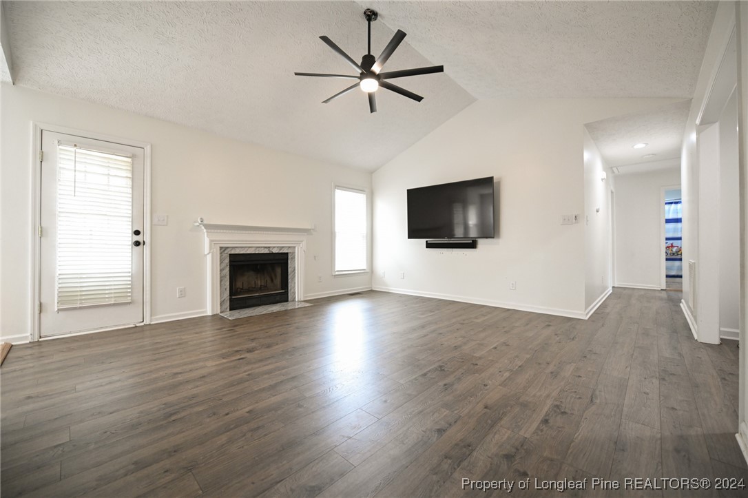 5057 Summer Ridge Road Fayetteville, NC 28303 - Photo 6 of 29 a view of a livingroom with a flat screen tv ceiling fan and a fireplace