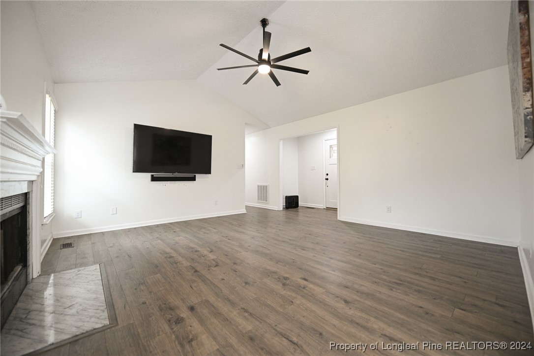 5057 Summer Ridge Road Fayetteville, NC 28303 - Photo 7 of 29 a view of a livingroom with a flat screen tv ceiling fan and wooden floor