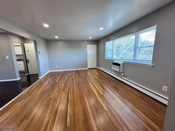 a view of a room with wooden floor and window