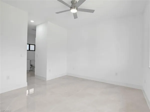 an empty room with a ceiling fan and carpet