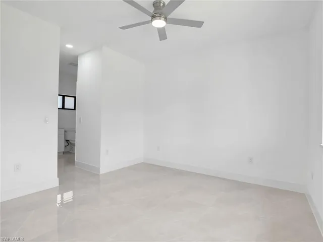 an empty room with a ceiling fan and carpet