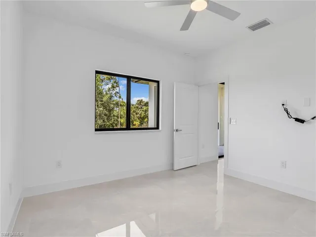 an empty room with a ceiling fan and a window