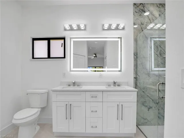 a bathroom with a toilet a sink and a mirror