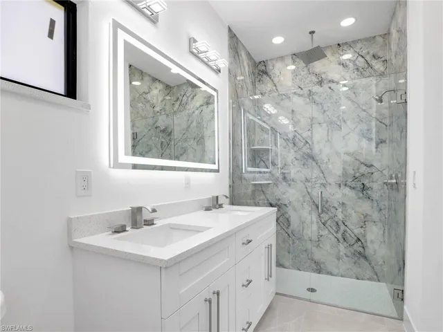 a bathroom with a sink mirror and a shower