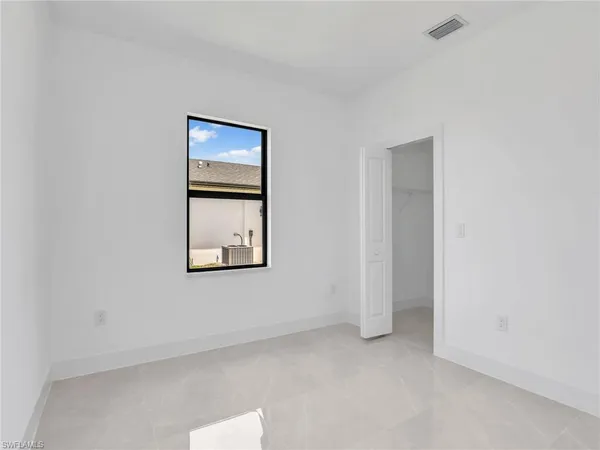 an empty room with windows and closet