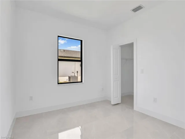 an empty room with windows and closet