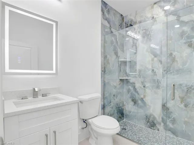a bathroom with a sink vanity mirror and toilet