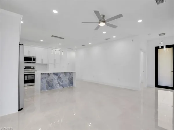 a view of kitchen with stainless steel appliances kitchen island refrigerator stove and oven