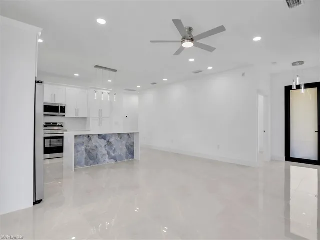 a view of kitchen with stainless steel appliances kitchen island refrigerator stove and oven