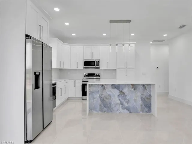 a large kitchen with cabinets stainless steel appliances and a counter top