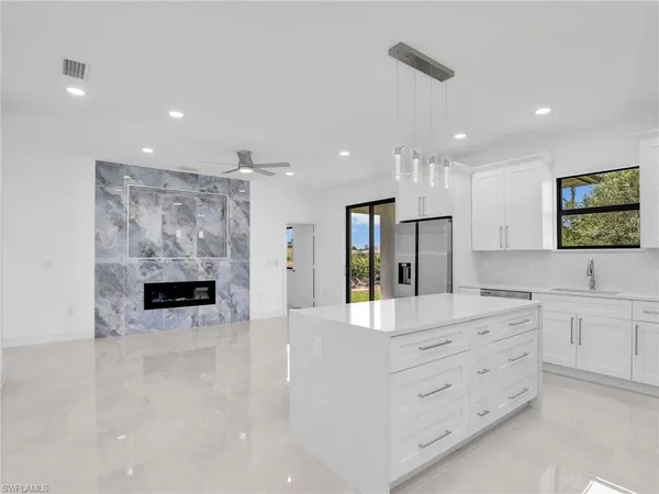 a kitchen with stainless steel appliances kitchen island granite countertop a refrigerator and a stove top oven