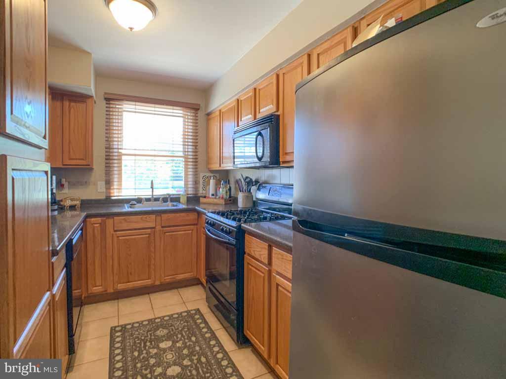 1148 Morefield Road Philadelphia, PA 19115 - Photo 11 of 35 a kitchen with stainless steel appliances granite countertop a sink stove and cabinets