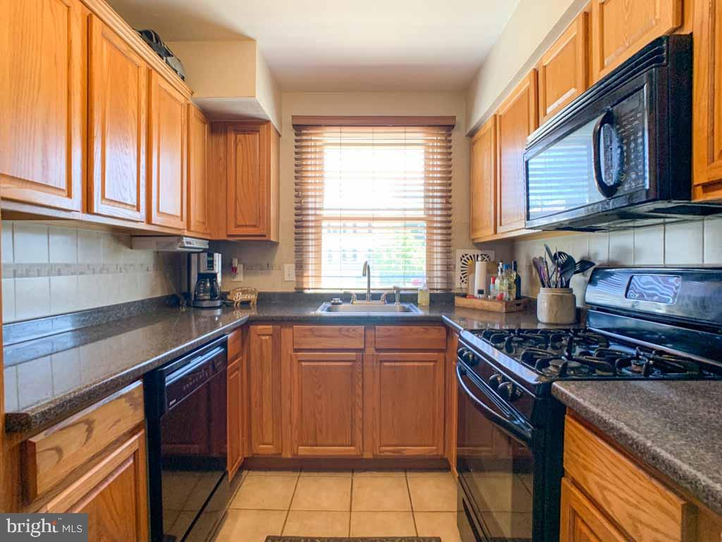1148 Morefield Road Philadelphia, PA 19115 - Photo 13 of 35 a kitchen with stainless steel appliances granite countertop a stove sink and cabinets