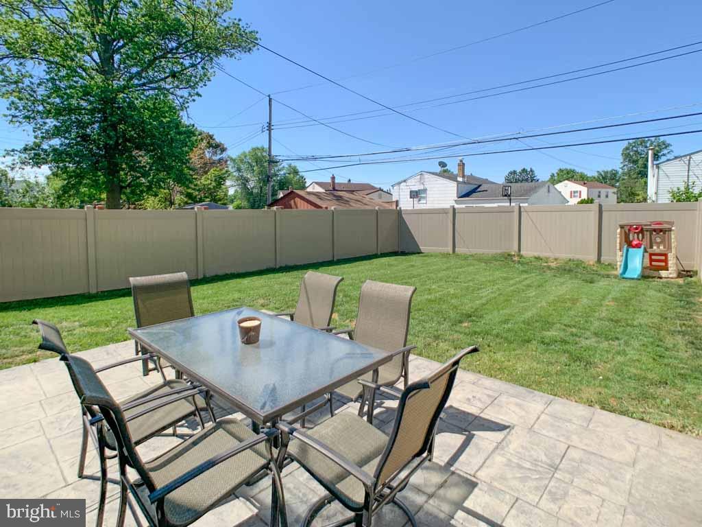 1148 Morefield Road Philadelphia, PA 19115 - Photo 31 of 35 a view of a backyard with table and chairs potted plants and wooden fence