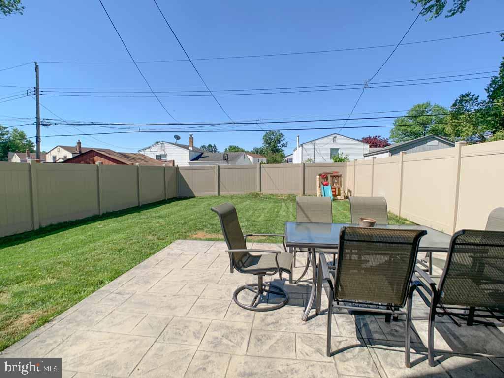 1148 Morefield Road Philadelphia, PA 19115 - Photo 32 of 35 a view of a patio with table and chairs potted plants and palm trees