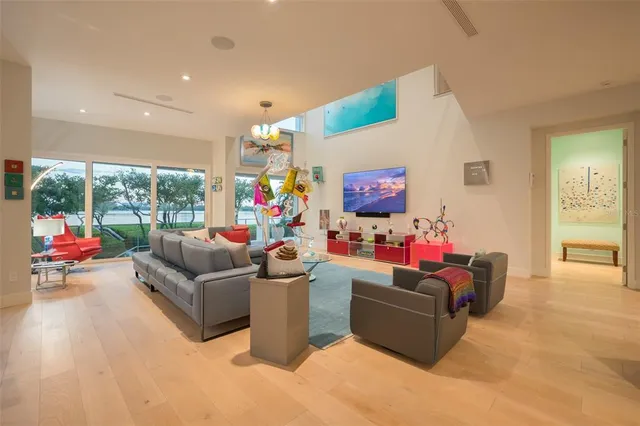 a view of a dining room with furniture one side kitchen view and wooden floor