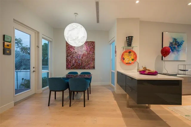 a kitchen with stainless steel appliances granite countertop a stove a sink a dining table and chairs