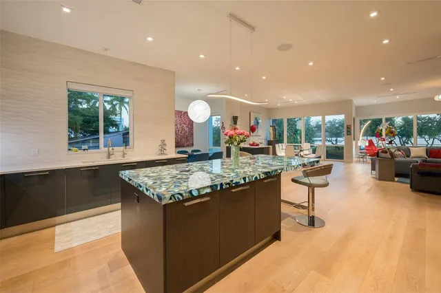 a kitchen with stainless steel appliances kitchen island granite countertop a sink and a refrigerator