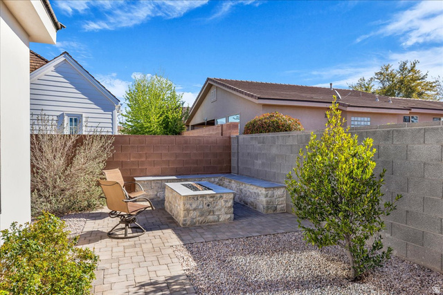 404 North Marsala Way St. George, UT 84770 - Photo 25 of 26 Fenced backyard featuring a fire pit and a patio area