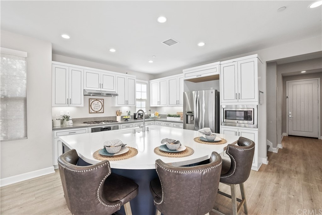 26 Lilac Lake Forest, CA 92630 - Photo 4 of 52 a kitchen with a dining table chairs and refrigerator