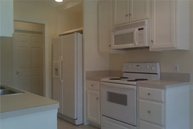a kitchen with a sink stove and cabinets