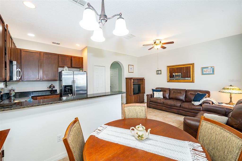 4113 Hedge Maple Place Winter Springs, FL 32708 - Photo 11 of 31 a living room with stainless steel appliances furniture a dining table and a chandelier