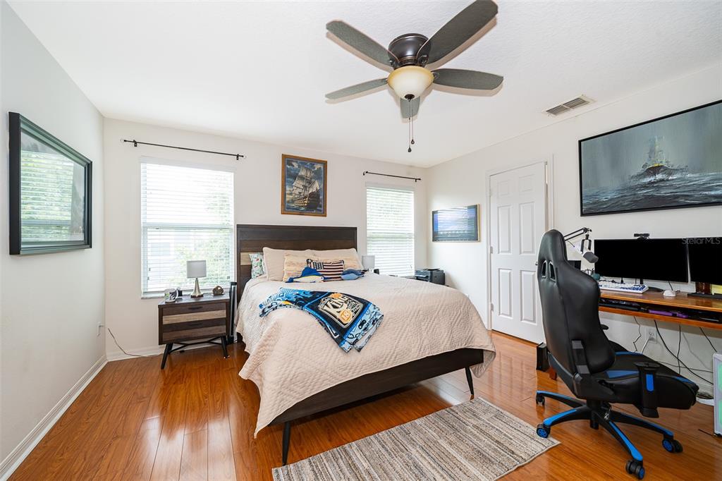 4113 Hedge Maple Place Winter Springs, FL 32708 - Photo 15 of 31 a bedroom with a bed a desk and chair with wooden floor