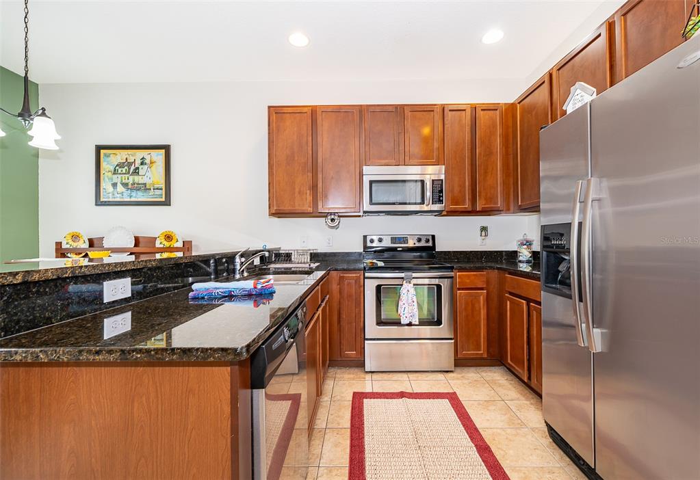 4113 Hedge Maple Place Winter Springs, FL 32708 - Photo 3 of 31 a kitchen with stainless steel appliances granite countertop a stove a sink and a refrigerator