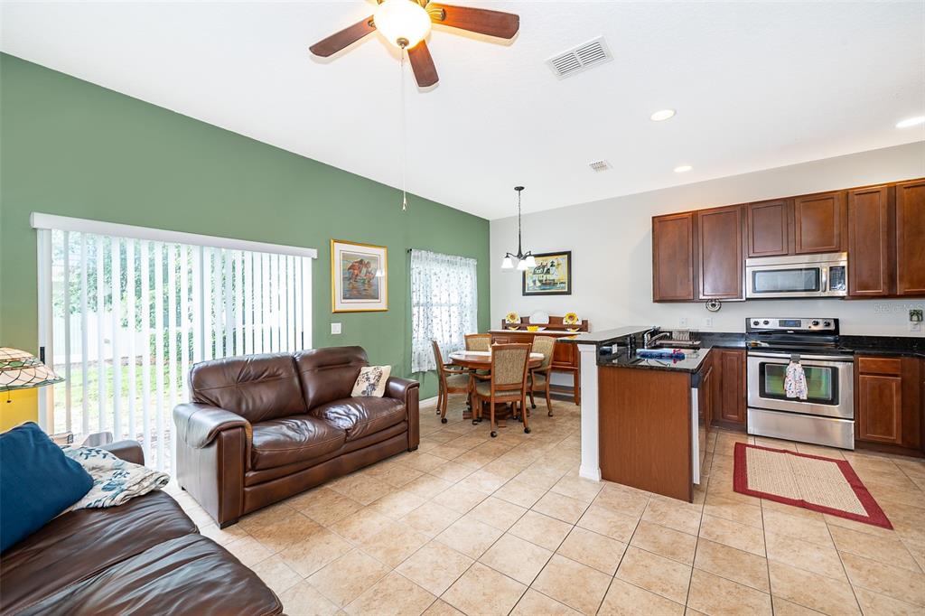 4113 Hedge Maple Place Winter Springs, FL 32708 - Photo 6 of 31 a living room with furniture and a kitchen area