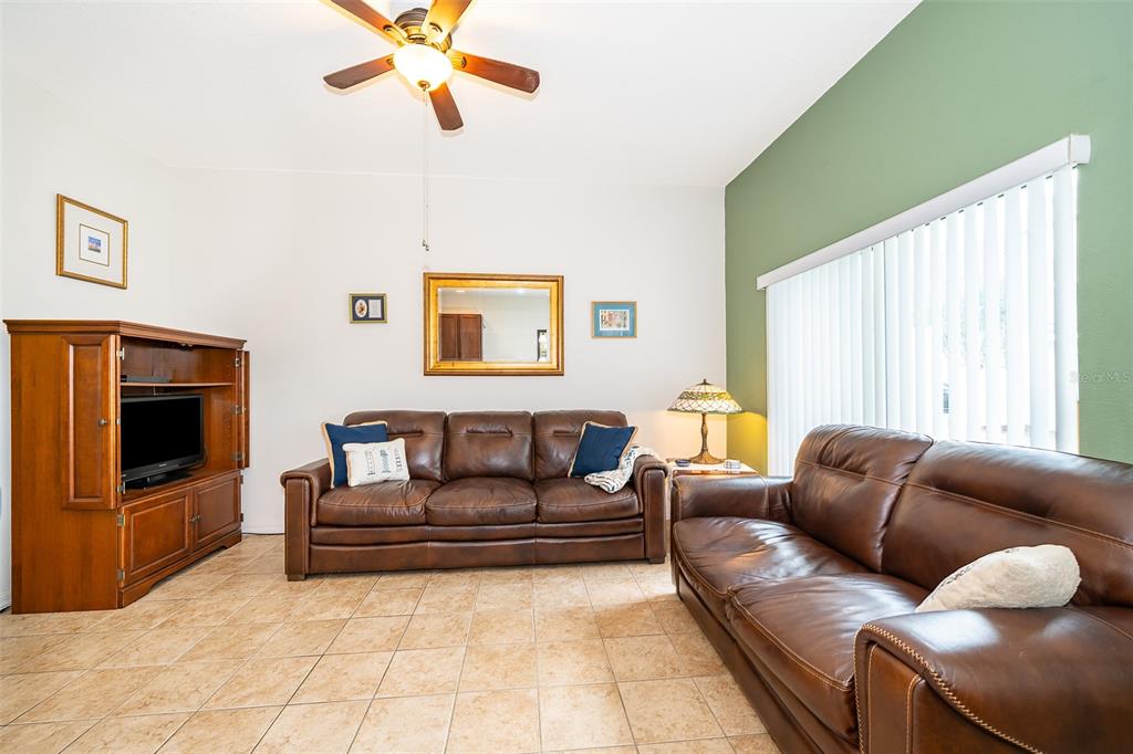 4113 Hedge Maple Place Winter Springs, FL 32708 - Photo 10 of 31 a living room with furniture a window and a flat screen tv